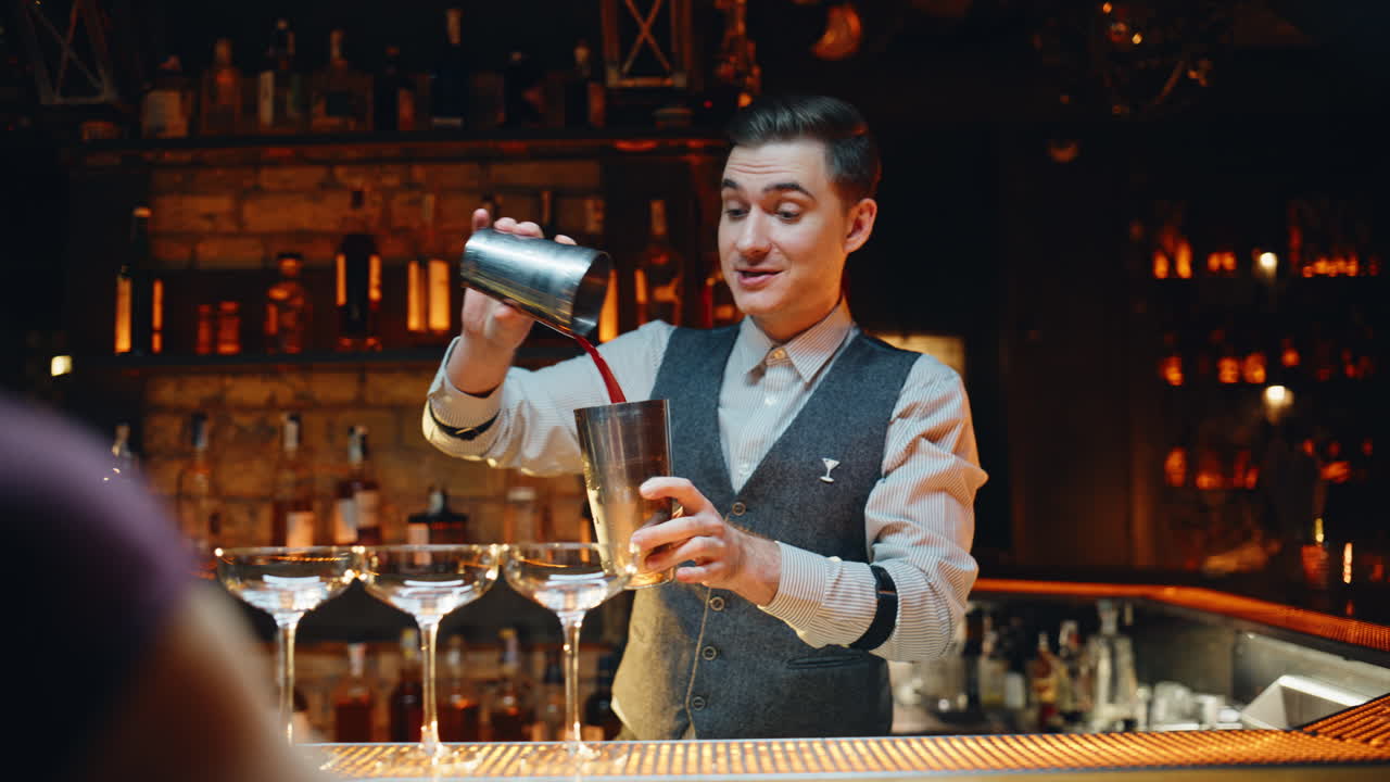Fröhlicher Barkeeper mixt Cocktail an polierter Holztheke, Nahaufnahme