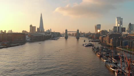 dolly-back-drone-shot-London-city-centre-tower-bridge-shard-gherkin-at-sunset