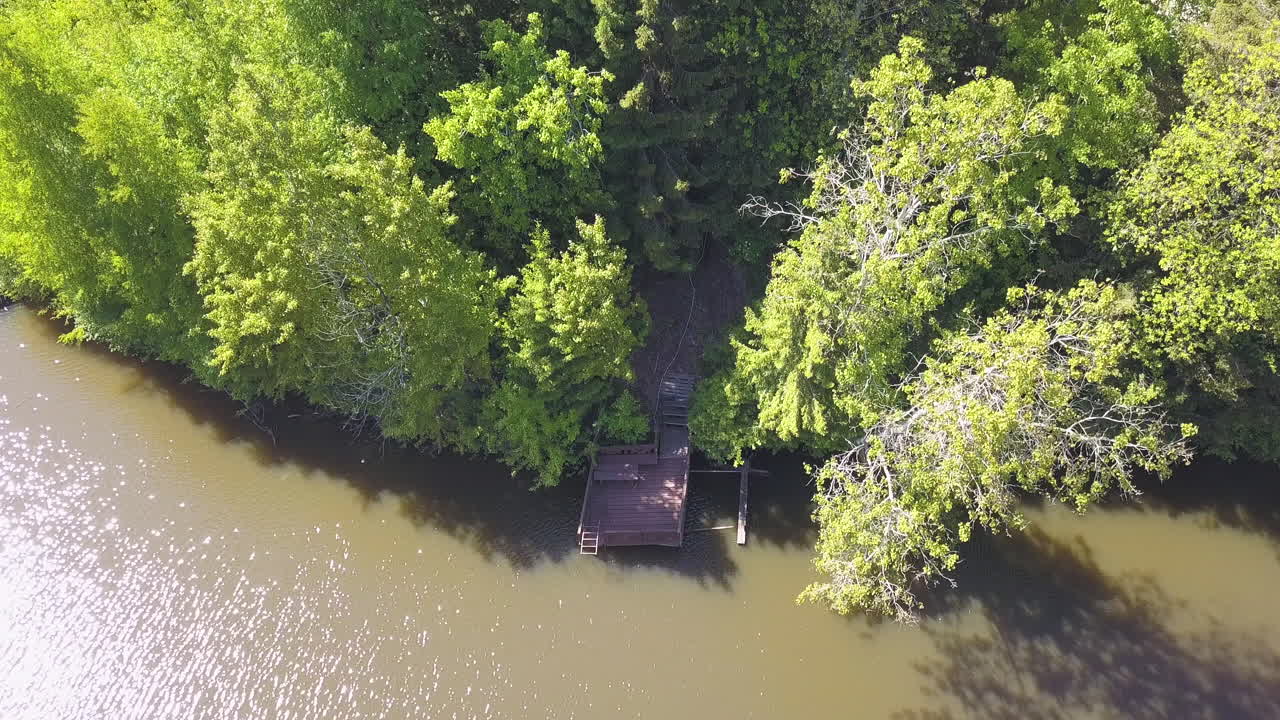 Aerial View of a Wooden Pier on a Riverbank in a Forest