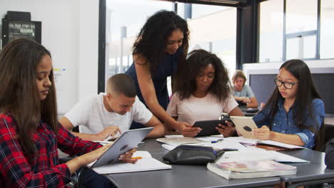 Profesor-Ayudando-A-Estudiantes-De-Secundaria-Con-Tecnología