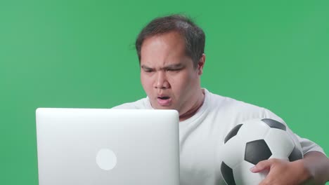 hombre viendo un juego de fútbol en una computadora portátil