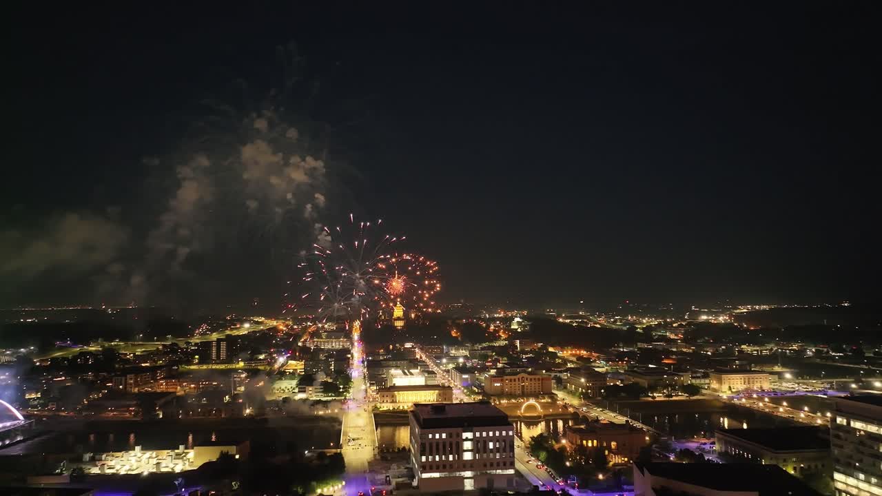 des moines, iowa fuegos artificiales sobre la ciudad y el edificio del capitolio estatal en el día de la independencia con video de drones moviéndose en un círculo de tiro ancho