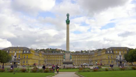 beautiful european castle with green grassy plaza in the city of stuttgart germany with people chilling and walking by