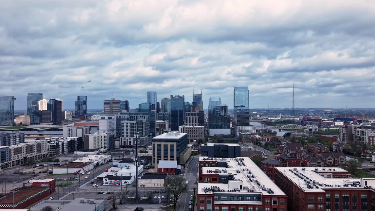 Central Nashville, Tennessee with the downtown city skyline on a cloudy day - flowing cloudscape forward aerial hyper lapse