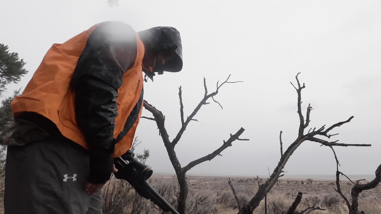 소총으로 조준하기 위해 무릎을 꿇고 필드 드레싱의 남성 사냥꾼