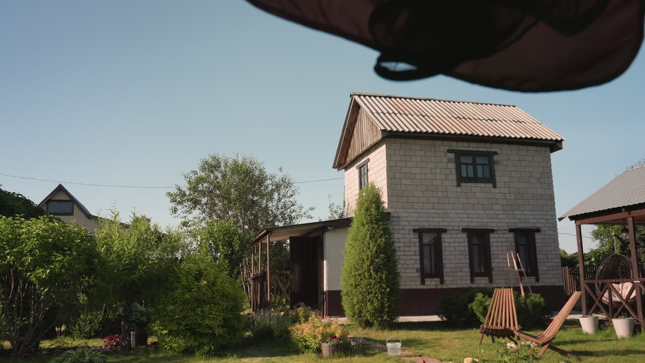 Radiant Rustic Landscape Featuring Cheerful House Amidst Vibrant Garden Scenery, Luminous Pastoral Setting Showcasing Delightful Countryside Home Amid Flourishing Plants And Clear Blue Sky