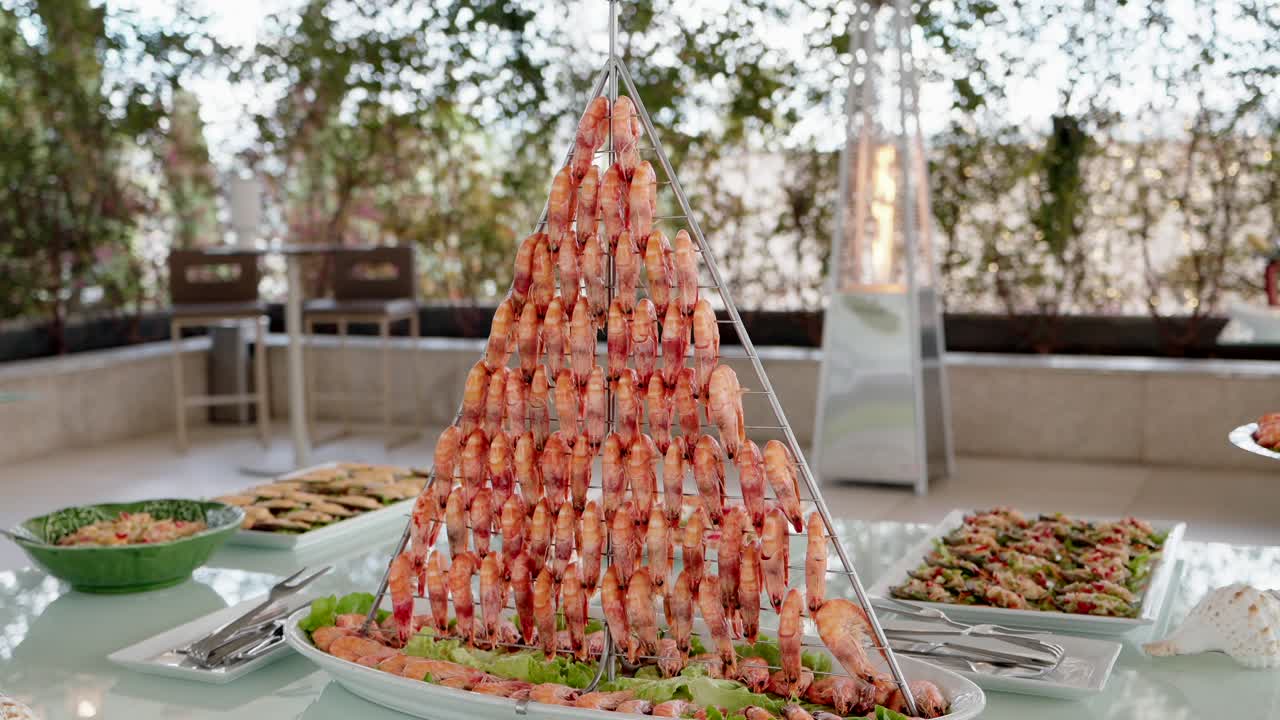 Primo piano di una torre di gamberi a piramide a un buffet di frutti di mare in un'elegante ambientazione per eventi al chiuso