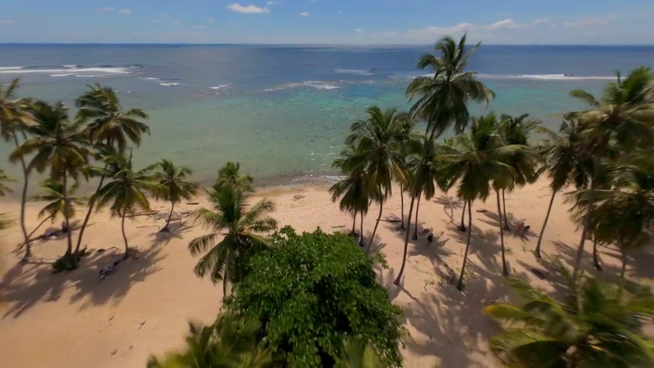 Sorvolo di una spiaggia estiva appartata di Playa Frontón nella Penisola di Samaná, Repubblica Dominicana. Ripresa FPV.