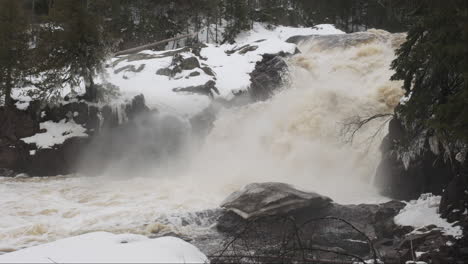 minnesota waterfall roars, its cascading waters swollen with the surge of spring's melting snow