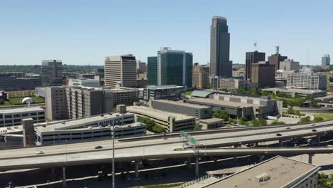 Coches-Circulando-Por-La-Autopista-Con-El-Centro-De-Omaha,-Horizonte-De-Nebraska-En-Segundo-Plano