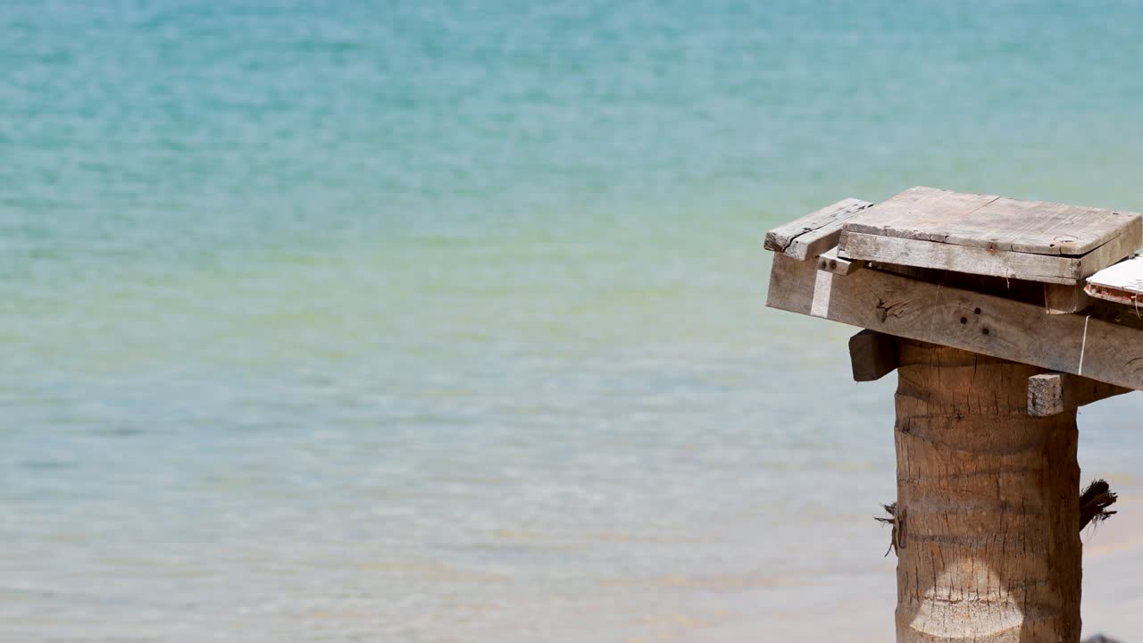 A serene ocean scene with a wooden jetty against a clear blue sea, captured in bright daylight