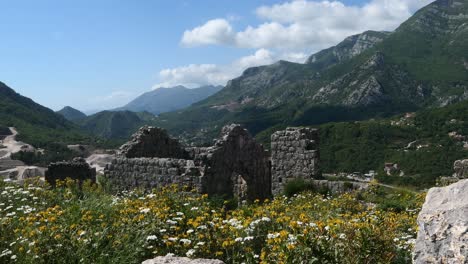 Old-fortress-and-ruins-surrounded-by-flowers-and-mountains,-Southern-Europe