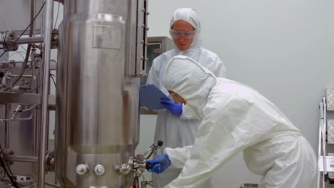 scientists in protective suits working together