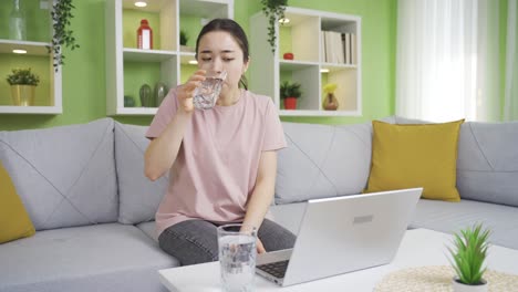 asian young woman drinking a lot of water at home.