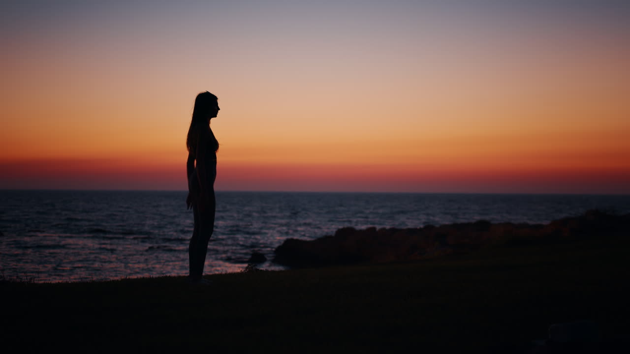 mujer haciendo sentadillas al atardecer en la playa