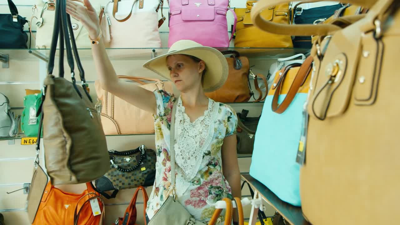 una mujer turista elige una bolsa en una tienda en la playa