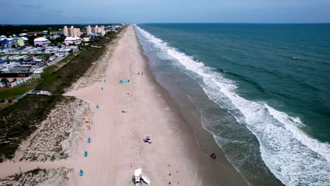 Wide-drone-shot-of-shoreline-with-just-a-few-people-on-the-sand