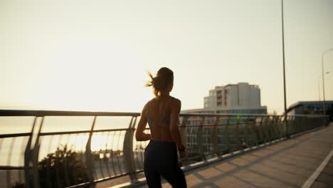 a girl in a sports uniform does her jogging in the evening. against the backdrop of the beautiful rays of the sun