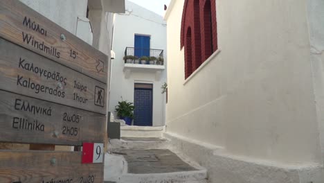 right pan from bi-lingual hiking sign to typical narrow greek alley