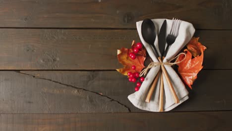 Video-of-cutlery,cloth-and-autumn-decoration-lying-on-wooden-surface