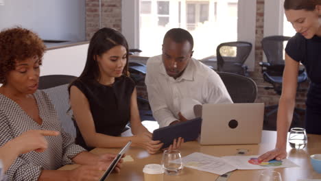 Group-Of-Businesspeople-Meeting-Around-Table-In-Office