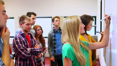 Young-students-writing-on-whiteboard-in-classroom