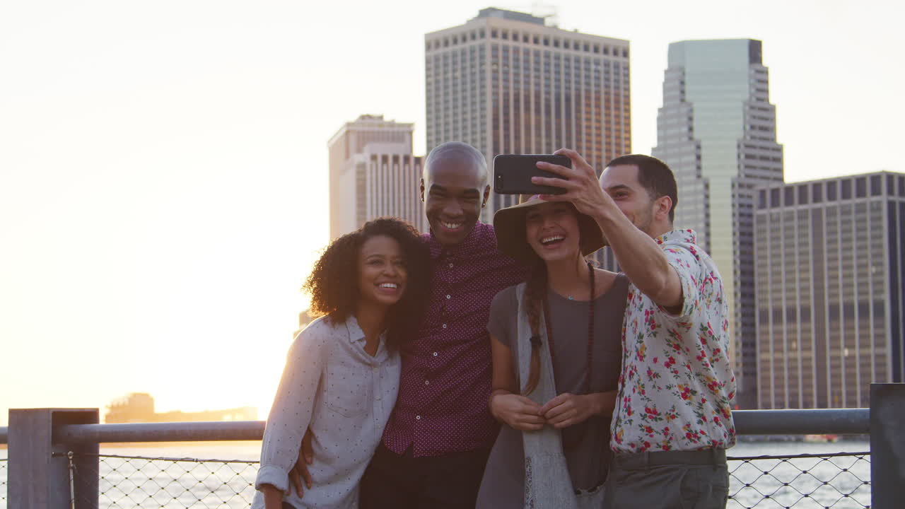 grupo de amigos posando para una selfie frente al horizonte de manhattan