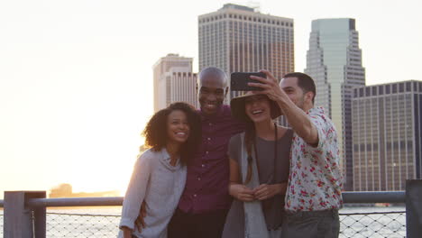 Group-Of-Friends-Posing-For-Selfie-In-Front-Of-Manhattan-Skyline