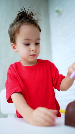 cute caucasian toddler in red t-shirt with messy hair plays at home. lovely kid playing with toys. vertical video.