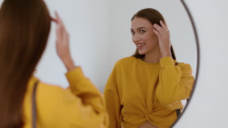 woman checking outfit in front of mirror