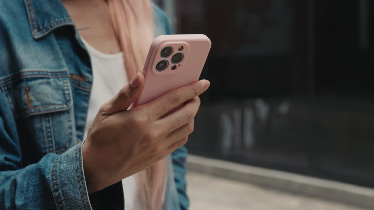 Woman using a pink iPhone with a protective case