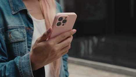 woman using a pink iphone with a protective case