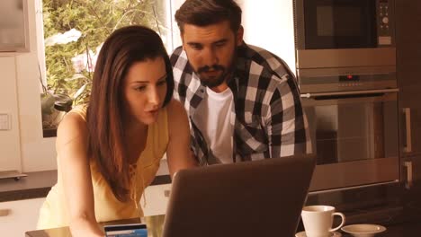 couple shopping online on laptop using credit card