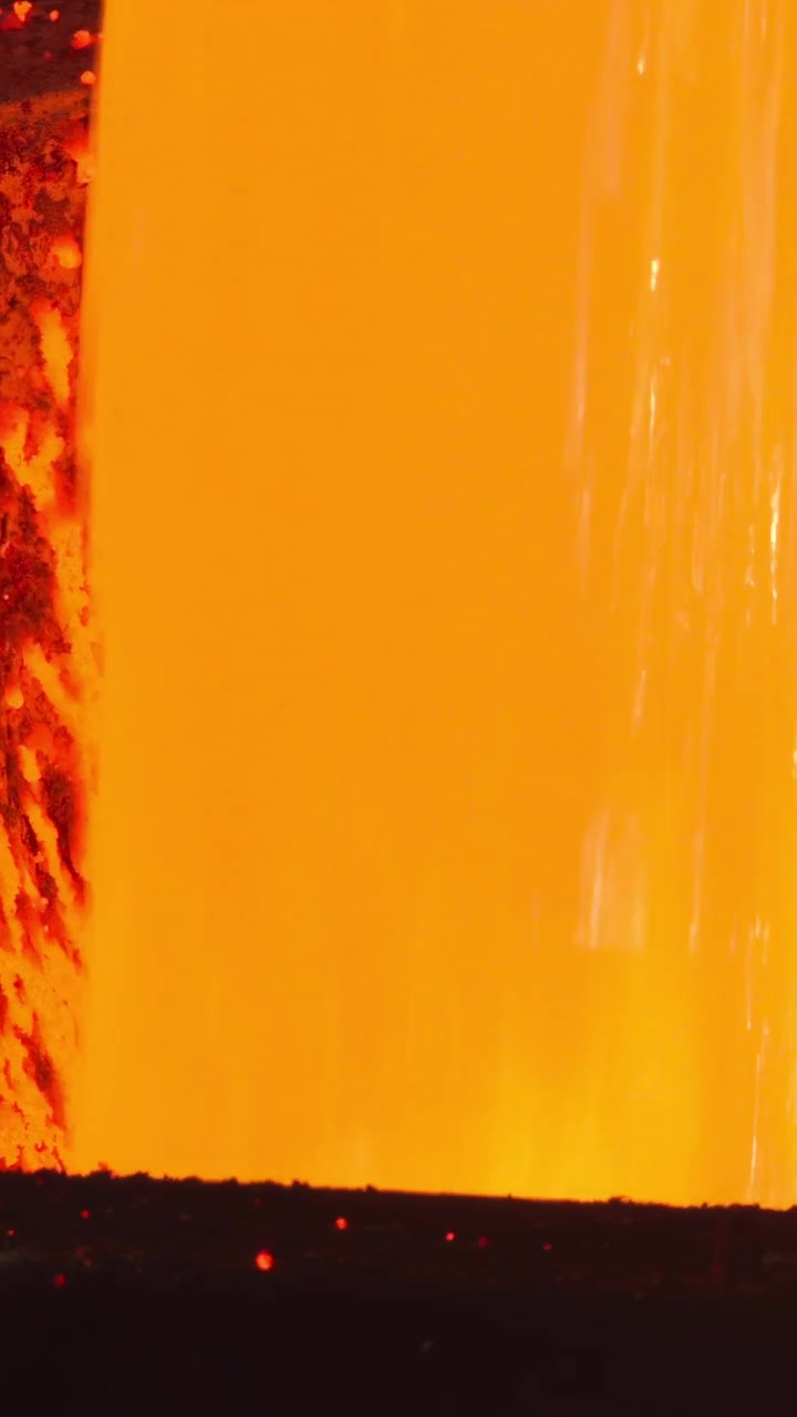Enorme cascata di metallo fuso che riempie una vasca di raccolta, superficie turbolenta e schiuma incandescente, flusso arancione ruggente
