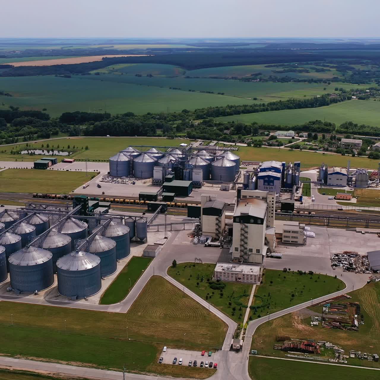 Agricultural plant for storage and processing crops outside the city. Well-organized plant territory with green areas and roads. Aerial view