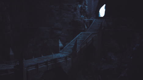 mysterious wooden staircase leads through dark cave to bright opening