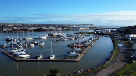 Drone-shot-orbiting-marina-and-boats-docked-on-Brighton-coast,-England