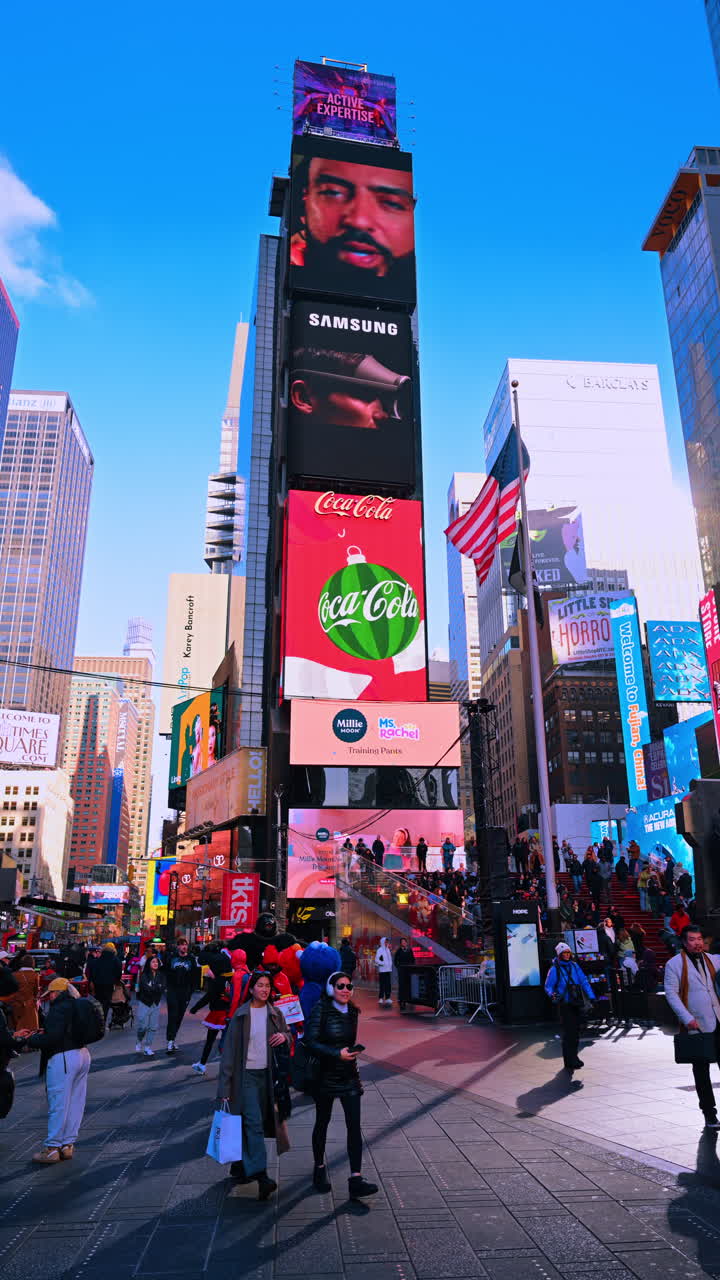 Nueva York, EE. UU., 18 de diciembre de 2025: Pantallas en los rascacielos de Nueva York, EE. UU. Anuncios de vallas publicitarias digitales al aire libre. Multitudes de personas caminan por Times Square durante el día. Video vertical.