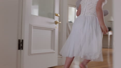 happy little girl running through house holding teddy bear wearing tutu excited to play outside child having fun on weekend morning enjoying childhood 4k footage