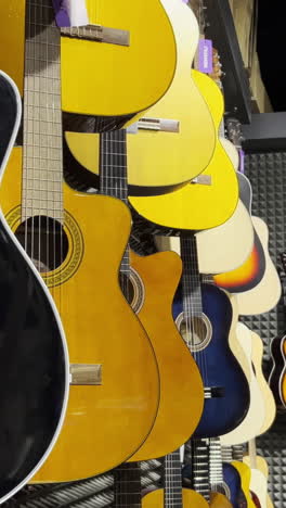 close up of multicolored acoustic guitars in a store. stringed musical instruments.