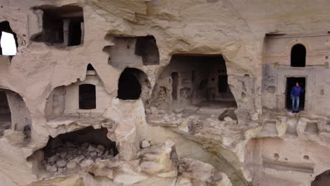 aerial view of a woman standing on ancient city carved in rock in cappadocia turkey