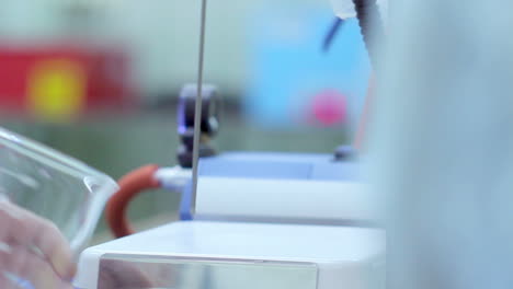 análisis de la leche. el científico puso una taza medidora con leche en el equipo de laboratorio