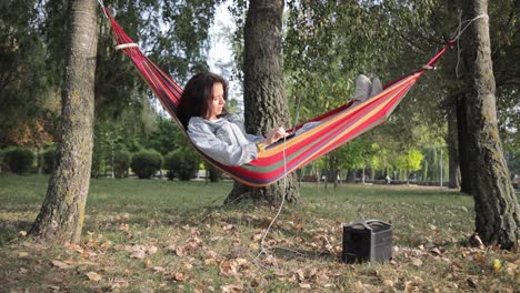 woman relaxing in a hammock with a laptop