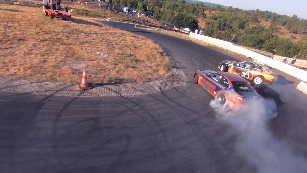 Close Up Aerial Action Follow Shot of 2 Cars Drifting on Track