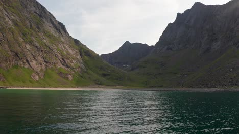 aerial shot of remote lofoten sandvika beach in noway surrounded by steep cliffs