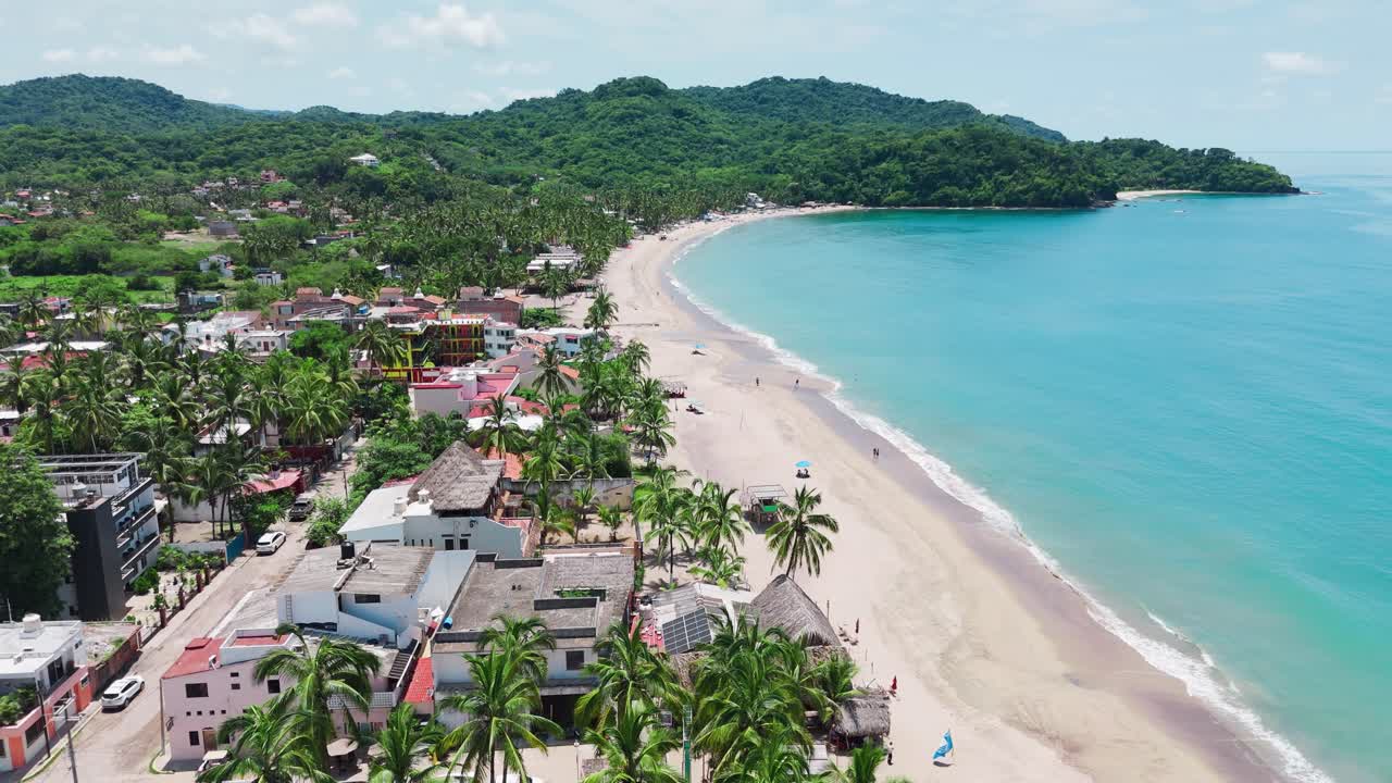 Aerial view of lo de marcos beach meeting the crystal clear waters of the pacific ocean, surrounded by lush vegetation in nayarit, mexico