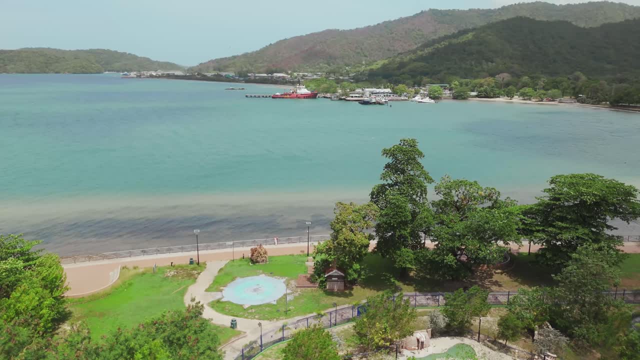 A drone’s aerial view reveals the stunning Chaguaramas boardwalk and Williams Bay on the coast of Trinidad in the Caribbean.