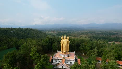 Aerial-drone-circling-Golden-Wat-Doi-Sapanyoo-with-a-large-staircase-leading-to-four-unique-buddha-statues-located-in-the-mountain-hills-of-Chiang-Mai-Thailand-surround-by-a-forest-on-a-sunny-day