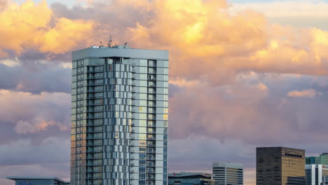 time lapse of glowing clouds passing behind the confluence apartment complex in denver, colorado