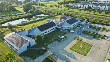 Luftaufnahme-Eines-Schönen-Bürogebäudes-Mit-Einem-Dach,-Das-Mit-Photovoltaik-Solarpaneelen-Gefüllt-Ist